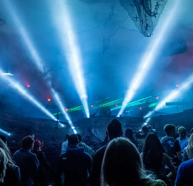 Crowd facing a blue-lit stage